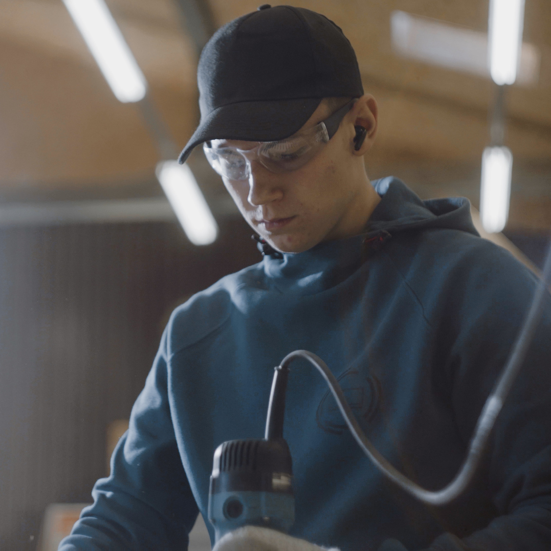 Pracownik używający narzędzia do obróbki płyty sosnowej